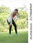 Small photo of Woman gets heatstroke, Sport woman gets in pink sport shirt Dizzy and Faint when she jogging or exercise outdoor with strong sunlight in summer season in Green City Park. She will be fainting