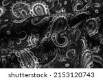 Small photo of Paisley black-white pattern on a black background. decorated the bandanas of cowboys and bikers popularized by The Beatles, ushered in the era of hippies and became the emblem of rock and roll.