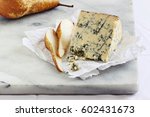 Small photo of Blue cheese and pear on a marble cutting board. Old english Stilton cheese.