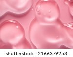 Cream gel drops red transparent cosmetic sample texture with bubbles on pink background