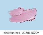 Small photo of Cosmetic pink nacreous satin texture smudge on blue background