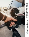 Small photo of Refueling the car at a gas station fuel pump. Man driver hand refilling and pumping gasoline oil the car with fuel at he refuel station. Car refueling on petrol station. Fuel pump at station