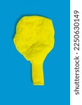 Small photo of A deflated yellow balloon on a blue background. One uninflated balloon top view. The concept of the ended holidays in the form of a half-deflated yellow balloon