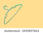 Small photo of Empty plastic hanger isolated on orange background close-up. Potential copy space above and inside clothes hangers. The green clothes hanger is empty without clothes. Potential space for text.
