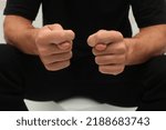 Small photo of Man's hands shows the fig isolated on white background. A man in black shows a negative obscene gesture with his hands. Negative gesture concept.