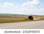 Small photo of Nizhny Novgorod, Russia - July 17, 2021: Wheat harvest season, cropper harvester harvesting wheat from the field. Sunny summer day in the village, agricultural work