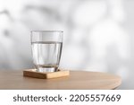 Transparent glass with water on a wooden table in the room. Drinking clear water in the morning for health.