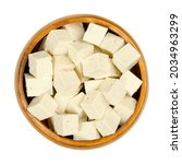 Small photo of Cubes of white tofu, in a wooden bowl. Diced bean curd, coagulated soy milk, pressed into white blocks of different softness. A component of Asian cuisine, and a meat substitute. Close-up, from above.