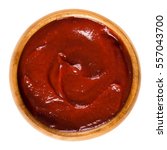 Tomato ketchup in wooden bowl. Also called catsup or ketsup, is a red table sauce made from tomatoes, often used as a condiment. Isolated macro food photo close up from above on white background.