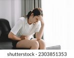 Small photo of Young asian woman stomach ache sitting on bed at home, Health problem Inflammation in body, Period cycle day of monthly, Menstruation concept.