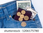 Small photo of Wallet, ready money and condom are lying in side pocket of blue jeans.