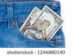 Small photo of Ready money and keys to the house on a keychain are lying in a side pocket of blue jeans.