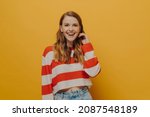 Small photo of Be Happy. Positive laughing millennial woman in casual clothes smiling after hearing funny joke or ridiculous anecdote from friend, posing isolated over yellow studio background. Positiveness concept