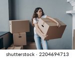 Small photo of Tired young woman renter exhausted of carrying heavy cardboard boxes with things on moving day. Upset hispanic girl tenant frowning leaving rented apartment. Mortgage, real estate tenancy concept