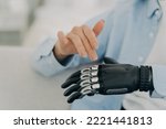 Small photo of Women with disability movements using bionic prosthesis of hand, touching, customizing artificial limb. Close up of womans healthy and prosthetic hands. Disability, high tech medical care concept.