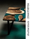 Small photo of Expensive vintage furniture. The table is covered with epoxy resin and varnished. Luxury quality wood processing. Wooden table on a concrete background. A nautical epoxy river in a rectangular slab.