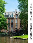 Small photo of Brugge, Belgium - May 15, 2022: Vintage building over lake of love in Minnewater park in Bruges Belgium near Beguinage monastery of Beguines. Picturesque landscape with green trees sunset time.