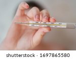 Girl holds a thermometer. High body temperature on a thermometer. 