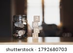 Small photo of English pound string coin and pennies nickels in jar with 2021 on wooden stack with blurry background,Financial planing for 2021 New Year resolution for saving money for future in business or life