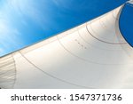 Small photo of White sails on the background of blue sky in the tropics. Sailing yacht on vacation in the ocean. Mast, boom, halyard, wind-filled sails - jib, spinnaker, genoa, mainsail. Rig, rope, backstay in Thai