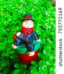 Small photo of small chimney sweeper sitting in the middle of a green plant with lots of leaves/happy new year, little lucky charm bringing luck on New Year's Eve/traditional superstition