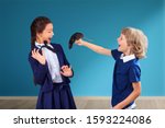 Small photo of Boy with rat teasing scared girl at school. Psychological bullying concept, tease, badger, taunt, mock, aggressive behavior. April Fool's Day joke