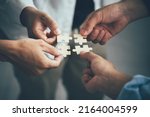 Small photo of Concept of teamwork and partnership. Hands join puzzle pieces in the office. business people putting the jigsaws team together.Charity, volunteer. Unity, team business.