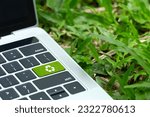 Small photo of environmental technology concept.green recycle button on a black keyboard on green grass. Recycle zero waste ecology saving technology. Circular technology for digital and environmental sustainability