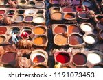 Small photo of Dye reservoirs and vats in traditional tannery of city of Fez, Morocco, with men working in the dye vats (viewed from from a Terrace)