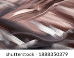 Abstract background chaotically smeared with acrylic paint. Image of a dark brown, beige, black and black strokes of brush with texture of wet stucco