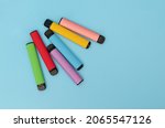 Small photo of Set of colorful disposable electronic cigarettes on a blue background. The concept of modern smoking. Top view