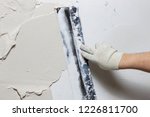 Construction worker plastering and smoothing concrete wall with cement 
