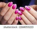 Women's hands with a gradient pink manicure. Nail design, manicure with gel polish