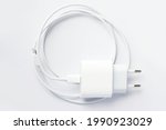 Top view of black phone AC charger and USB cable on white background.
