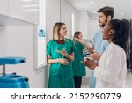 Small photo of Young group of oral surgeons looking at x-ray while preparing for surgery procedure. Diverse dental doctors working together. Medical, radiology and oral surgery concept.