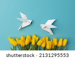Yellow tulips and two white birds as a symbol of peace on a blue background. There is no war. Stop the war.