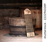 Small photo of Authentic old laundry wringer washboard in a wooden half barrel tub