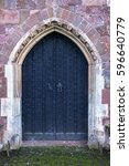 Small photo of Close-up of traditional medieval wood entrance doorway with ancient brick arc in Crediton Parish Church of the Holy Cross and the Mother of Him Who Hung thereon, Devon, UK, March 4, 2017