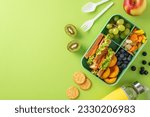 Small photo of Lunch in the school cafeteria concept. Above view photo of lunch box with sandwiches, fruits and vegetables and water bottle on light green isolated background with copyspace for text or advert