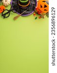 Small photo of Enthralling kids' Halloween night celebration idea. Overhead vertical shot of sweets, witch hat and Halloween-themed embellishments on an isolated green setting, allowing space for adverts or text