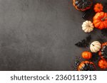 Create a spooky Halloween mood with this top view arrangement: thematic decor, pumpkins, creepy spiders, spiderweb, bat, and a small coffin on dark grunge concrete, text space available