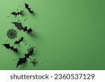 Small photo of Immerse in a Halloween masterpiece! Top-down view of spooky decorations: ghastly spiders, cobweb, flying bats. Green background with confetti and an empty space for your message or promotion