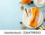 Viewed from above, a warm Thanksgiving gathering comes to life with golden dishes, cutlery and fall-themed accents adorn light blue isolated setting, designed for text or promotional content
