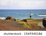 Man standing at cliff at Mokuleia Beach Park, Kaena Point at the North Shore  on Oahu Island, Hawaii, United States of America.