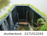 Small photo of The highlight of place is the flowing water like a small waterfall curtain. Water overflowing the mortar weir during the rainy season with bench is under at Pang Sawan Weir, Uthai Thani, Thailand.
