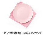 Empty isolated pink plate with pink napkin on white bakground. Food background for menu or recipe. Table setting. Flatlay, top view. mockup for restaurant dish