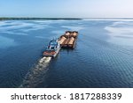 A large barge with sand sails along the coast along the wide Volga river