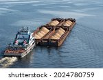A Tugboat Pushes Barges With...