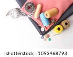 Sewing accessories and fabric on a white background. Sewing threads, needles, pins, fabric, buttons and sewing centimeter.
 top view, flatlay