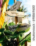 Small photo of Wooden arrows signboards on the beach resort. Spider House. Wahine beach bar